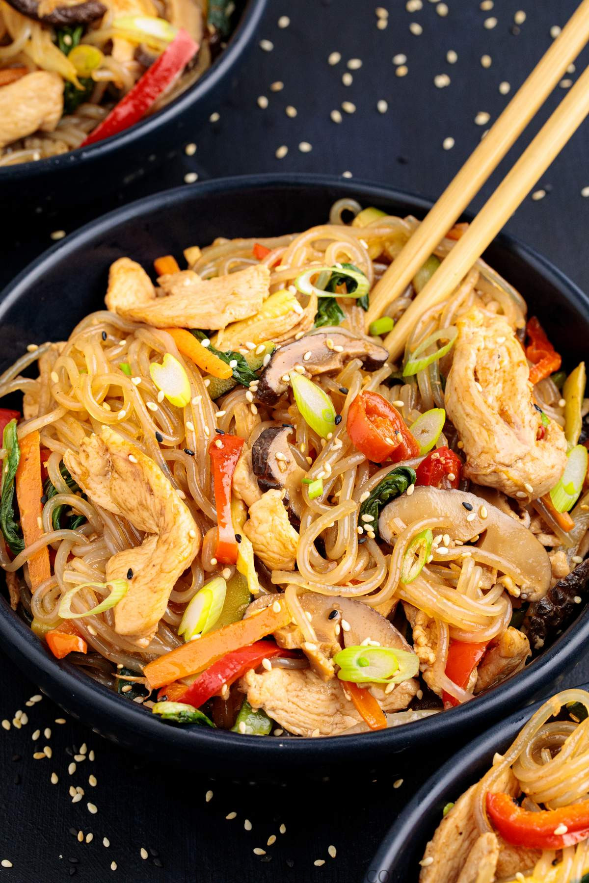 Overhead view of bowls filled with Korean Chicken Japchae Noodle Stir-Fry