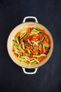 Vegetables being stir fried in a large pot