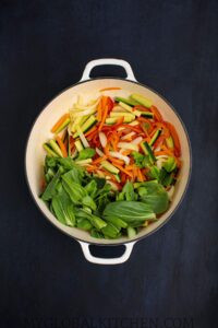 Adding the spinach to the vegetable stir fry
